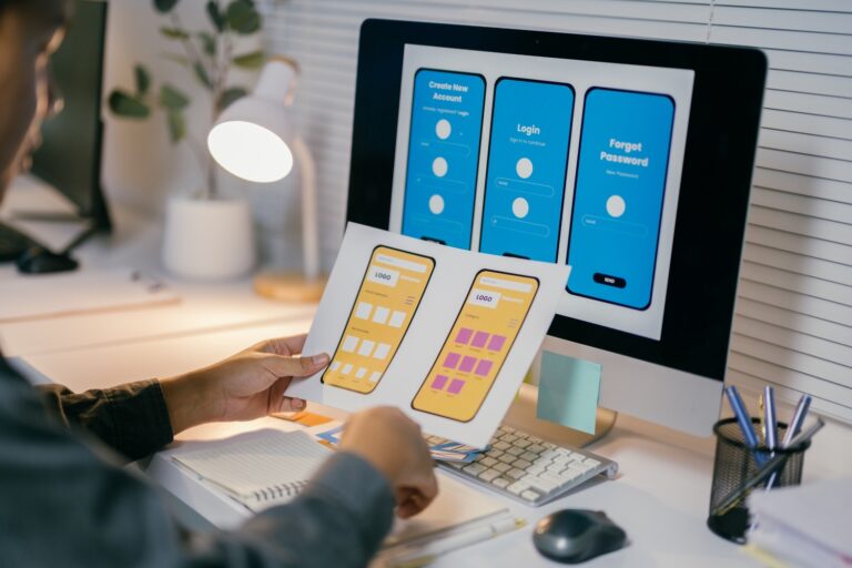 ux designer is reviewing paper prototypes of a mob NLR769M